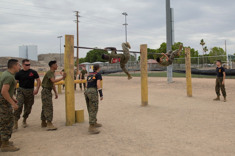 U.S. Marine Corps Sgt. Jesse Clay, Sgt. Jenna Cauble, and Sgt. Alberto Deloreyes, instructors with Corporals Course class 6-18, Marine Corps Air Station (MCAS) Yuma, Ariz., motivate students as they conduct an obstacle course on MCAS Yuma, Ariz., June 15, 2018. Marines, Sailors and Airmen attended the two week course focused on Marine Corps leadership, standards, professional development and physical fitness. (U.S. Marine Corps photo by Sgt. Allison Lotz)