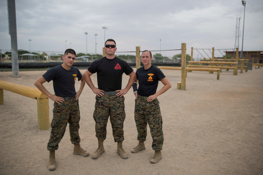 U.S. Marine Corps Sgt. Jesse Clay, Sgt. Jenna Cauble, and Sgt. Alberto Deloreyes, instructors with Corporals Course class 6-18, Marine Corps Air Station (MCAS) Yuma, Ariz., pose for a group photo after conducting an obstacle course on MCAS Yuma, Ariz., June 15, 2018. Marines, Sailors and Airmen attended the two week course focused on Marine Corps leadership, standards, professional development and physical fitness. (U.S. Marine Corps photo by Sgt. Allison Lotz)