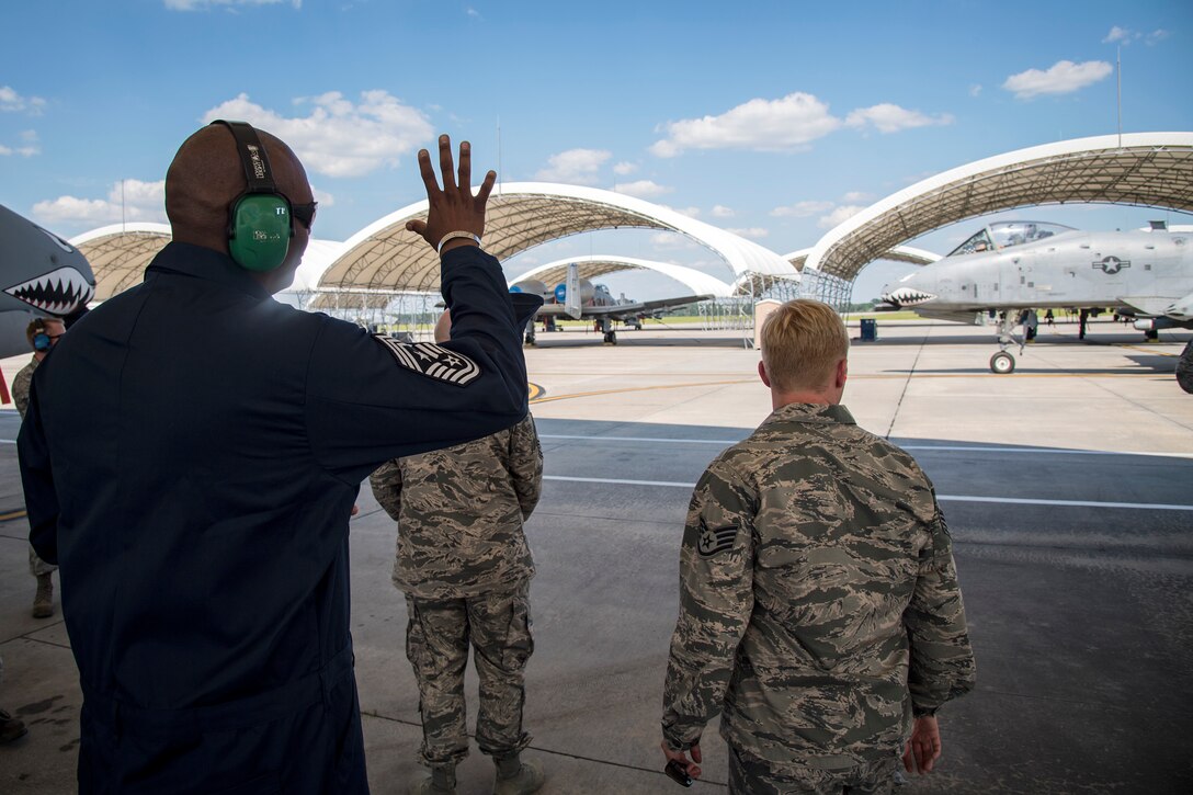 Chief Master Sgt. James Allen, 23d Wing command chief, rear, waves at an A-10C Thunderbolt II pilot during an immersion tour, July 10, 2018, at Moody Air Force Base, Ga. Allen toured the 23d Aircraft Maintenance Squadron (AMXS) to build rapport and experience the day to day operations of maintenance Airmen. Throughout his visit, Allen was able to speak with Airmen and hear their opinions and ideas behind the continued success of the AMXS. (U.S. Air Force photo by Airman 1st Class Eugene Oliver)