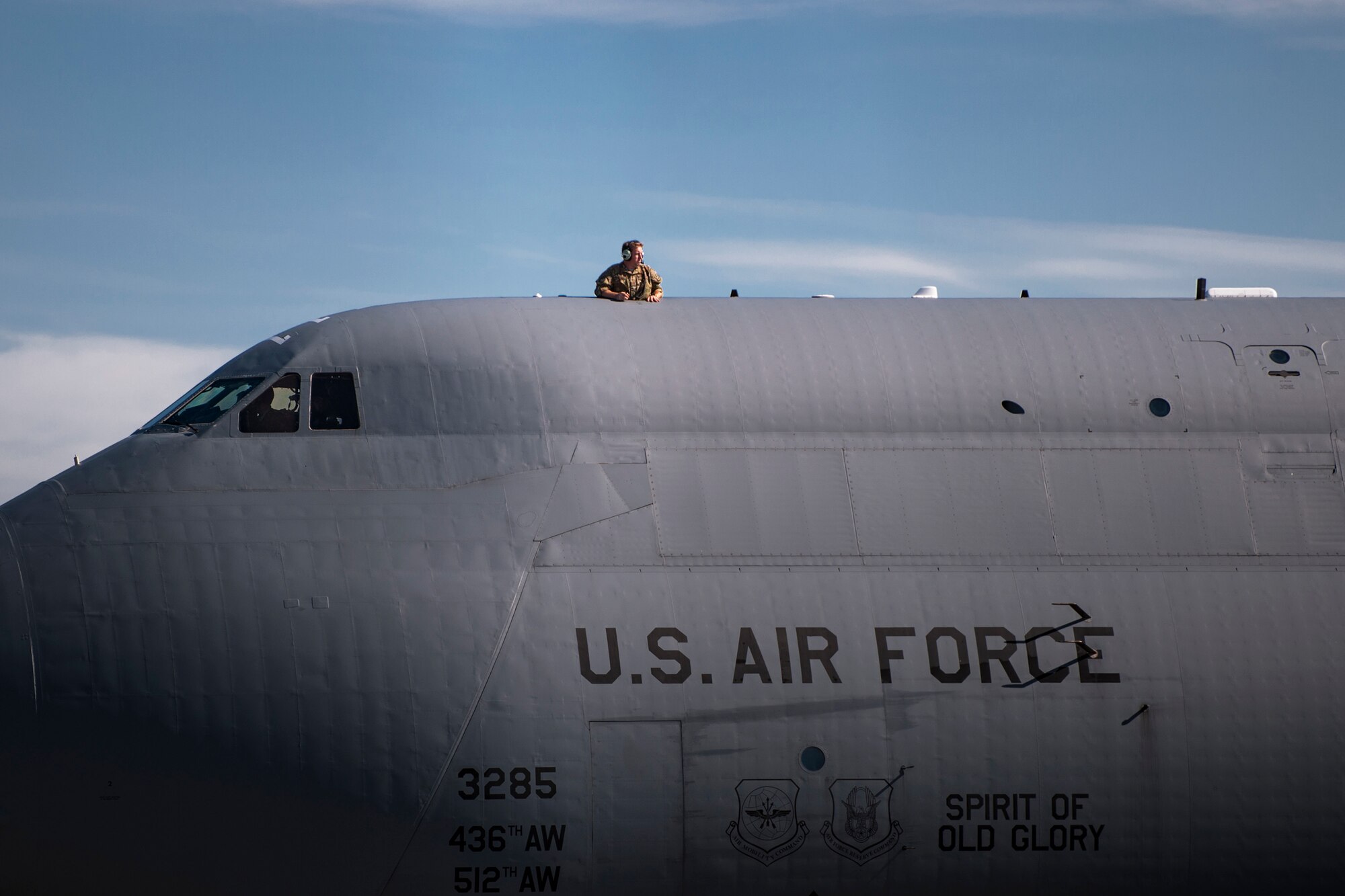 An Airman looks out onto the flightline on top of a C-5 Galaxy during the 41st Rescue Squadron’s (RQS) redeployment ceremony, July 10, 2018, at Moody Air Force Base, Ga. While deployed, the 41st RQS and the 41st Helicopter Maintenance Unit provided combat search and rescue capabilities and maintenance operations in support of Combined Joint Task Force-Horn of Africa. (U.S. Air Force photo by Airman Taryn Butler)