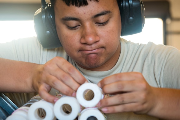 Airman 1st Class Jordan Sili, 23d Maintenance Squadron (MXS) crew member, ties linked tube carriers together during a 30mm rounds processing, July 11, 2018, at Moody Air Force Base, Ga. This total force integration training with the 23d and 476th MXS allowed Airmen to work together to identify more ways to efficiently and safely conduct their mission. The munitions flight ensures the A-10C Thunderbolt IIs are armed with 30mm rounds to make sure they are able to continue their mission while at home station and deployed. (U.S. Air Force photo by Airman 1st Class Erick Requadt)