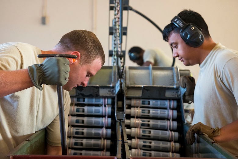 Tech. Sgt. Robert Lewis, left, 476th Maintenance Squadron (MXS) NCO in charge of line delivery, and Airman 1st Class Jordan Sili, 23d MXS crew member, feed munitions into ammo bins during a 30mm rounds processing, July 11, 2018, at Moody Air Force Base, Ga. This total force integration training with the 23d and 476th MXS allowed Airmen to work together to identify more ways to efficiently and safely conduct their mission. The munitions flight ensures the A-10C Thunderbolt IIs are armed with 30mm rounds to make sure they are able to continue their mission while at home station and deployed. (U.S. Air Force photo by Airman 1st Class Erick Requadt)