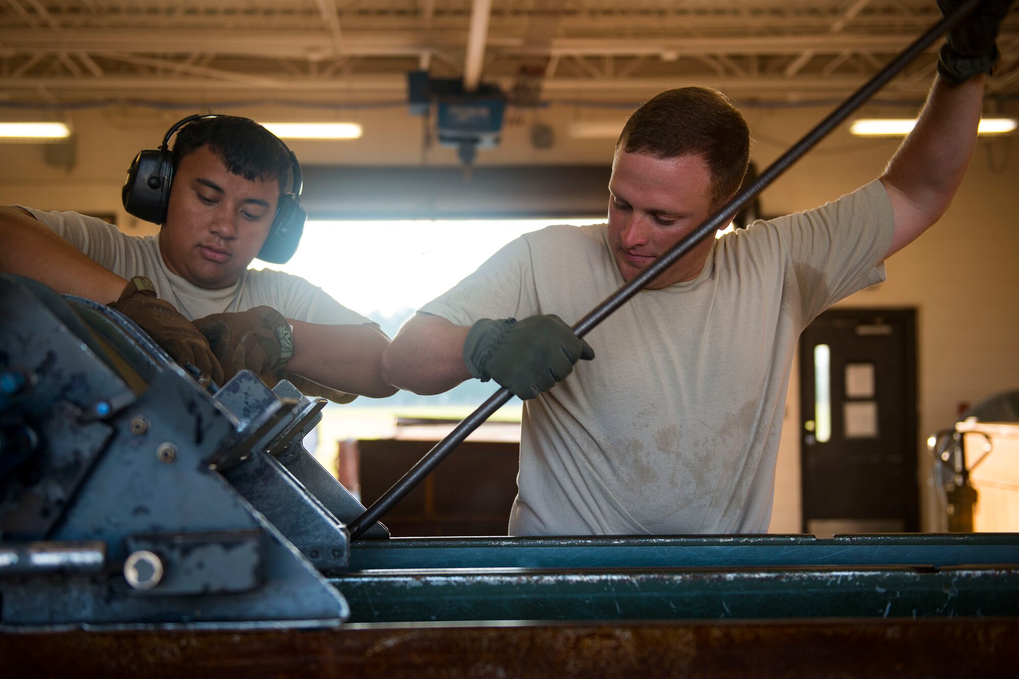 Tech. Sgt. Robert Lewis, right, 476th Maintenance Squadron (MXS) NCO in charge of line delivery, and Airman 1st Class Jordan Sili, 23d MXS crew member, work on feeding munitions through a GFU-7 rail system during a 30mm rounds processing, July 11, 2018, at Moody Air Force Base, Ga. This total force integration training with the 23d and 476th MXS allowed Airmen to work together to identify more ways to efficiently and safely conduct their mission. The munitions flight ensures the A-10C Thunderbolt IIs are armed with 30mm rounds to make sure they are able to continue their mission while at home station deployed. (U.S. Air Force photo by Airman 1st Class Erick Requadt)
