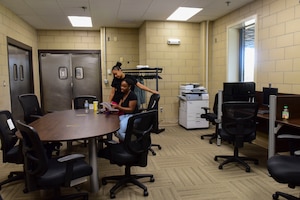 U.S. Air Force Airmen 1st Class Dyamon Abrahams, (left), and Chelsi Knott, 633rd Force Support Squadron services journeyman, read paperwork in the Crossbow Dining Facility at Joint Base Langley-Eustis, Virginia, July 10, 2018. Dining facility renovations included a new office with an upgraded heating, ventilation and air conditioning system and computer work stations for training. (U.S. Air Force photo by Airman 1st Class Monica Roybal)