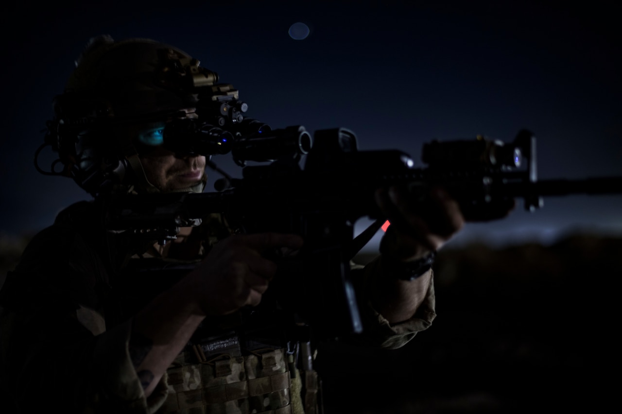 Pararescue airman aims rifle.