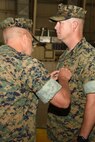 U.S. Marine Corps Col. Bret Ritterby, Marine Aviation Training and Support Group 22 commanding officer, pins a Meritorious Service Medal onto Maj. Andrew Armstrong, Marine Corps Detachment Goodfellow outgoing commanding officer, during the Marine Corps Detachment Goodfellow Change of Command at the Louis F. Garland Department of Defense Fire Academy on Goodfellow Air Force Base, Texas, July 10, 2018. The change of command is a transfer of total responsibility, authority and accountability from one Marine to another. (U.S. Air Force photo by Staff Sgt. Joshua Edwards/Released)