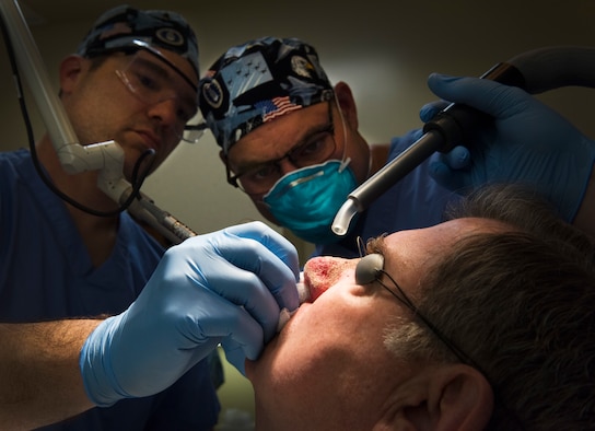 Col. (Dr.) Chad Hivnor (left), a dermatologist at the 59th Medical Wing, and Maj. Thomas Beachkofsky (right), a dermatologist at the 6th MDG, use air to cool the skin of a patient who is undergoing laser surgery at MacDill Air Force Base, Florida, March 9, 2018. Hivnor is working to expand capabilities of dermatology clinics in the Air Force.