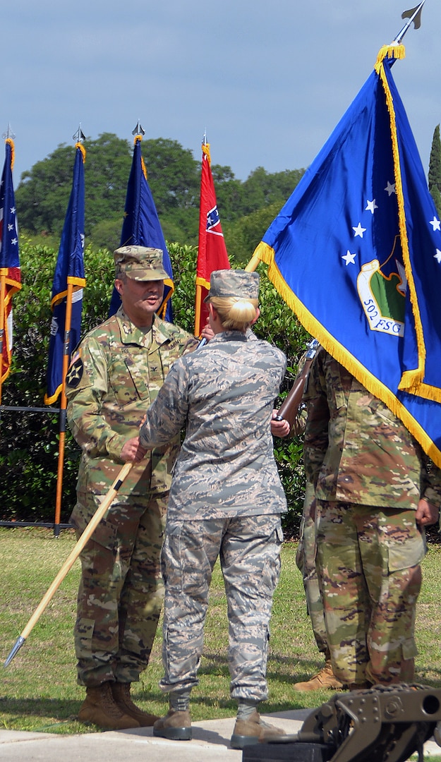 Col. Samuel E. Fiol (left) receives the 502nd Force Support Group colors from Brig. Gen. Laura L. Lenderman, 502nd Air Base Wing and Joint Base San Antonio commander, during a change of command ceremony held at the JBSA-Fort Sam Houston base flagpole July 11, where he took over for outgoing commander Col. David L. Raugh.