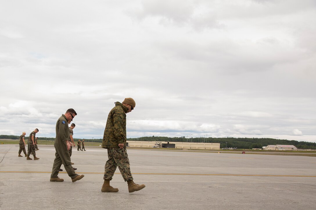 U.S. Marines assigned to Marine Attack Squadron (VMA) 214 conduct a Foreign Object Debris (FOD) walk in preparation for the arrival of their AV-8B Harriers at Joint Base Elmendorf-Richardson, Alaska, June 27, 2018. VMA-214 will participate in the 2018 Arctic Thunder Air Show with a flyby, hover demonstration, and a static display. (U.S. Marine Corps photo by Lance Cpl. Sabrina Candiaflores)
