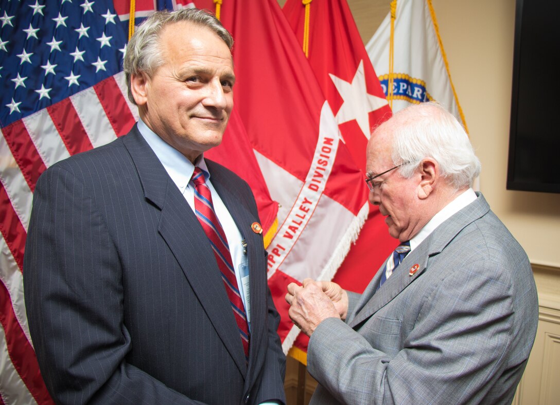 Sam Angel, the Mississippi River Commission's longest standing member, pins James A. Reeder, the MRC's newest member, after Reeder's swearing-in at the MRC headquarters in Vicksburg, Miss., July 11, 2018.