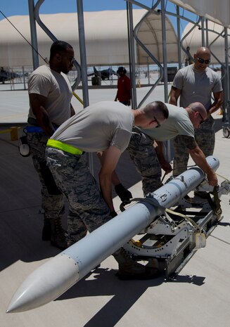 U.S. Airmen attached to the 4th Aircraft Maintenance Unit, Hill Air Force Base, Utah, load ordnance on to an F-35B Lightning II on MCAS Yuma Ariz., June 26, 2018. The exercise tested, for the first time, the interoperability of loading weapon systems between the services F-35's. The U.S. Air Force Operates with the F-35A Lightning II, while the U.S. Marine Corps Operates with the F-35B Lightning II. (U.S. Marine Corps photo by Lance Cpl. Joel Soriano)