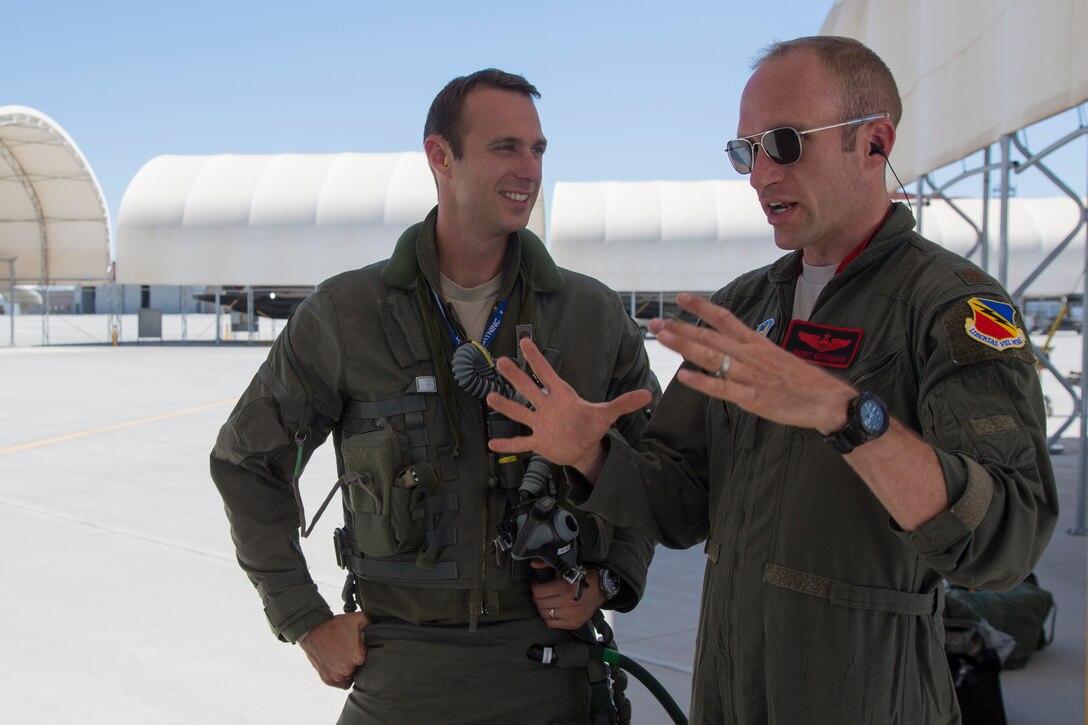 U.S. Airmen Maj. Caleb "Skeet" Guthman, and Capt. Timothy "Check" Six, pilots, attached to Hill Air Force Base, Utah, discuss upcoming exercises with U.S. Marines on MCAS Yuma, Ariz., June 26, 2018. The exercise tested, for the first time, the interoperability of loading weapon systems between the services F-35's. The U.S. Air Force operates with the F-35A Lightning II, while the U.S. Marine Corps operates with the F-35B Lightning II. (U.S. Marine Corps photo by Sgt. Allison Lotz)