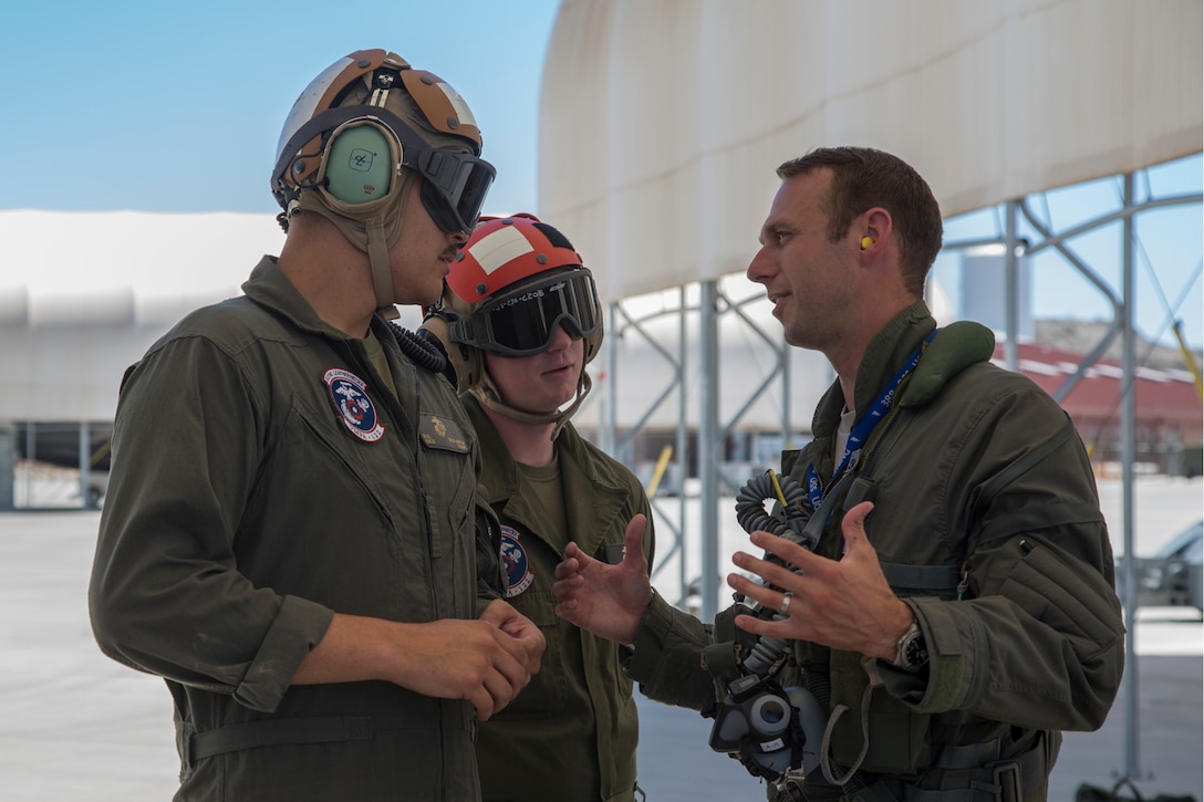 U.S. Airman Capt. Timothy "Check" Six, a pilot, attached to Hill Air Force Base, Utah, discusses upcoming exercises with U.S. Marine Corps Staff Sgt. Richard R. Wharton, and Lance Cpl. James Parker, aviation ordnance technicians with Marine Fighter Attack Squadron (VMFA) 122, Marine Corps Air Station (MCAS) Yuma, on MCAS Yuma, Ariz., June 26, 2018. The exercise tested, for the first time, the interoperability of loading weapon systems between the services F-35's. The U.S. Air Force operates with the F-35A Lightning II, while the U.S. Marine Corps operates with the F-35B Lightning II. (U.S. Marine Corps photo by Sgt. Allison Lotz)