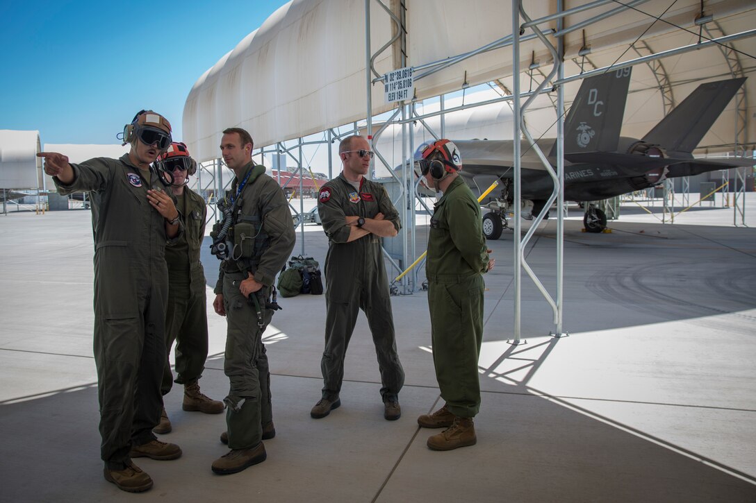 U.S. Airmen Maj. Caleb "Skeet" Guthman, and Capt. Timothy "Check" Six, pilots, attached to Hill Air Force Base, Utah, discuss upcoming exercises with U.S. Marines on MCAS Yuma, Ariz., June 26, 2018. The exercise tested, for the first time, the interoperability of loading weapon systems between the services F-35's. The U.S. Air Force operates with the F-35A Lightning II, while the U.S. Marine Corps operates with the F-35B Lightning II. (U.S. Marine Corps photo by Sgt. Allison Lotz)