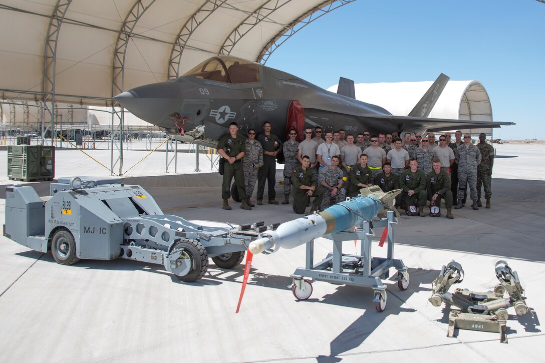 U.S. Marines with Marine Fighter Attack Squadron (VMFA) 122, Marine Corps Air Station (MCAS) Yuma, pose for a group photo with U.S. Airmen attached to the 4th Aircraft Maintenance Unit, Hill Air Force Base, Utah, during an exercise on MCAS Yuma, Ariz., June 26, 2018. The exercise tested, for the first time, the interoperability of loading weapon systems between the services F-35's. The U.S. Air Force operates with the F-35A Lightning II, while the U.S. Marine Corps operates with the F-35B Lightning II. (U.S. Marine Corps photo by Sgt. Allison Lotz)