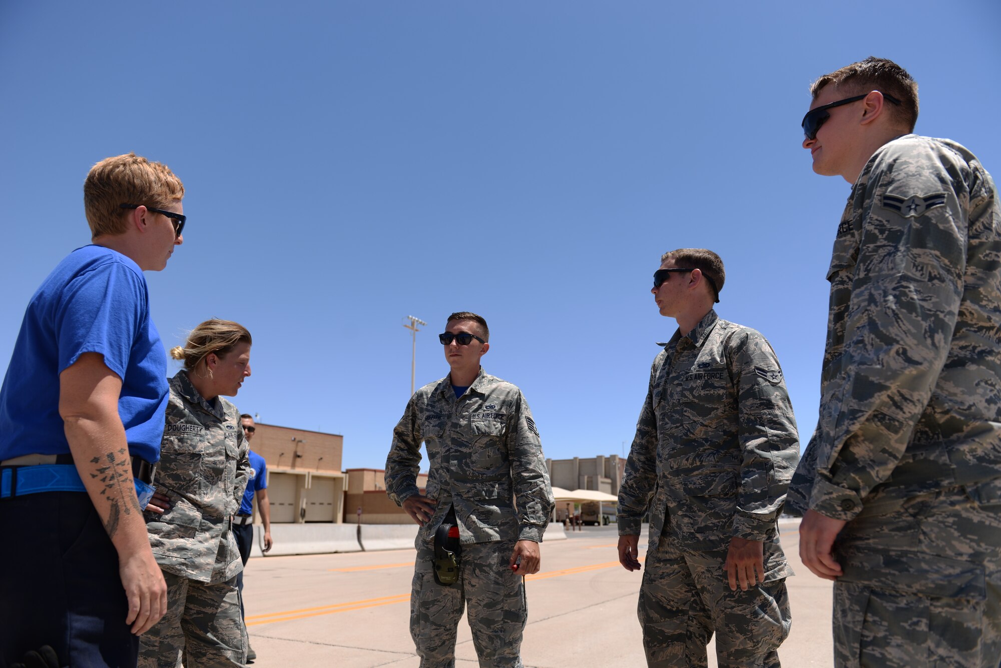 Lightning Integrated Technician team members discuss maintenance procedures before taxiing in aircraft June 8, 2018, at Luke Air Force Base, Ariz. Maintainers from independent career fields, including crew chiefs, avionics technicians, weapons technicians, and low-observable technicians, who all operate separately in traditional maintenance, were integrated into the LIT team using cross utilization training and shared work procedures. (U.S. Air Force photo by Senior Airman Ridge Shan)