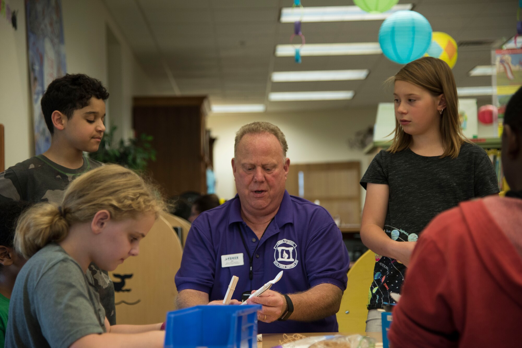 Jim Campbell, Joint Base Elmendorf-Richardson Library technician, builds a catapult with Science Club attendees at the JBER Library, July 5, 2018. JBER Library staff create unique Science, Technology Engineering and Math experiments year-round for Science Club.