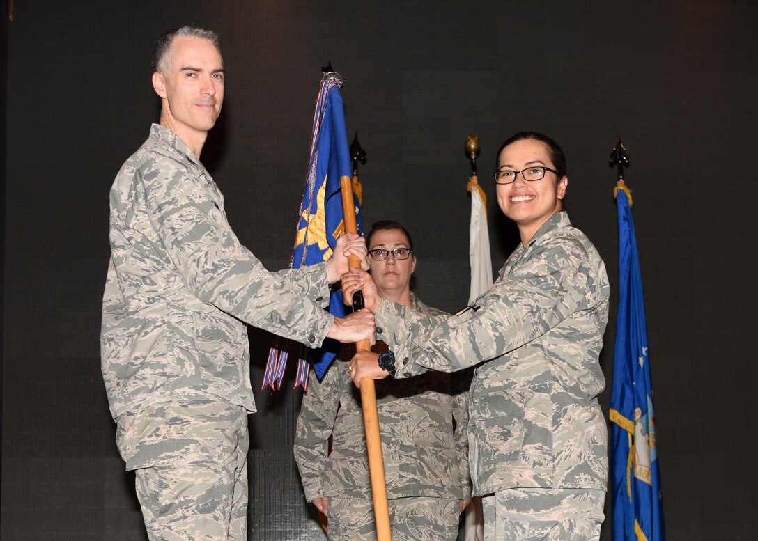 Col. Casey Campbell, 51st Medical Group commander, gives the 51st Medical Group guidon to Lt. Col. Jennifer Lavergne during a change of command ceremony at the Enlisted Club, June 29, 2018. During the ceremony, Lt. Col. Jennifer Lavergne took command of the 51st Medical Support squadron from Lt. Col. Charles Marek, 51st MDSS outgoing commander. (U.S. Air Force photo by Airman 1st Class Ilyana A. Escalona)