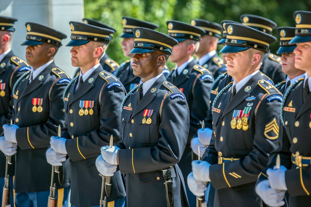 Rows of soldiers stand shoulder to shoulder.