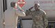 Airman 1st Class Luke Gayle, 332nd Expeditionary Logistics Readiness Petrolium Oil Lubricant distributor, salutes Col. Bryce Silver, 332nd Expeditionary Operations Group commander, after receiving a coin for outstanding performance at an undisclosed location in Southwest Asia, July 6, 2018.