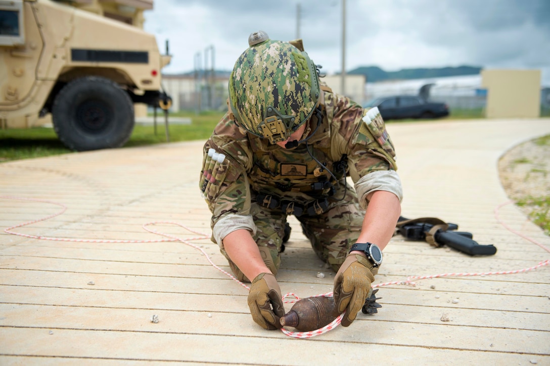 A sailor places a rope around a mortar.