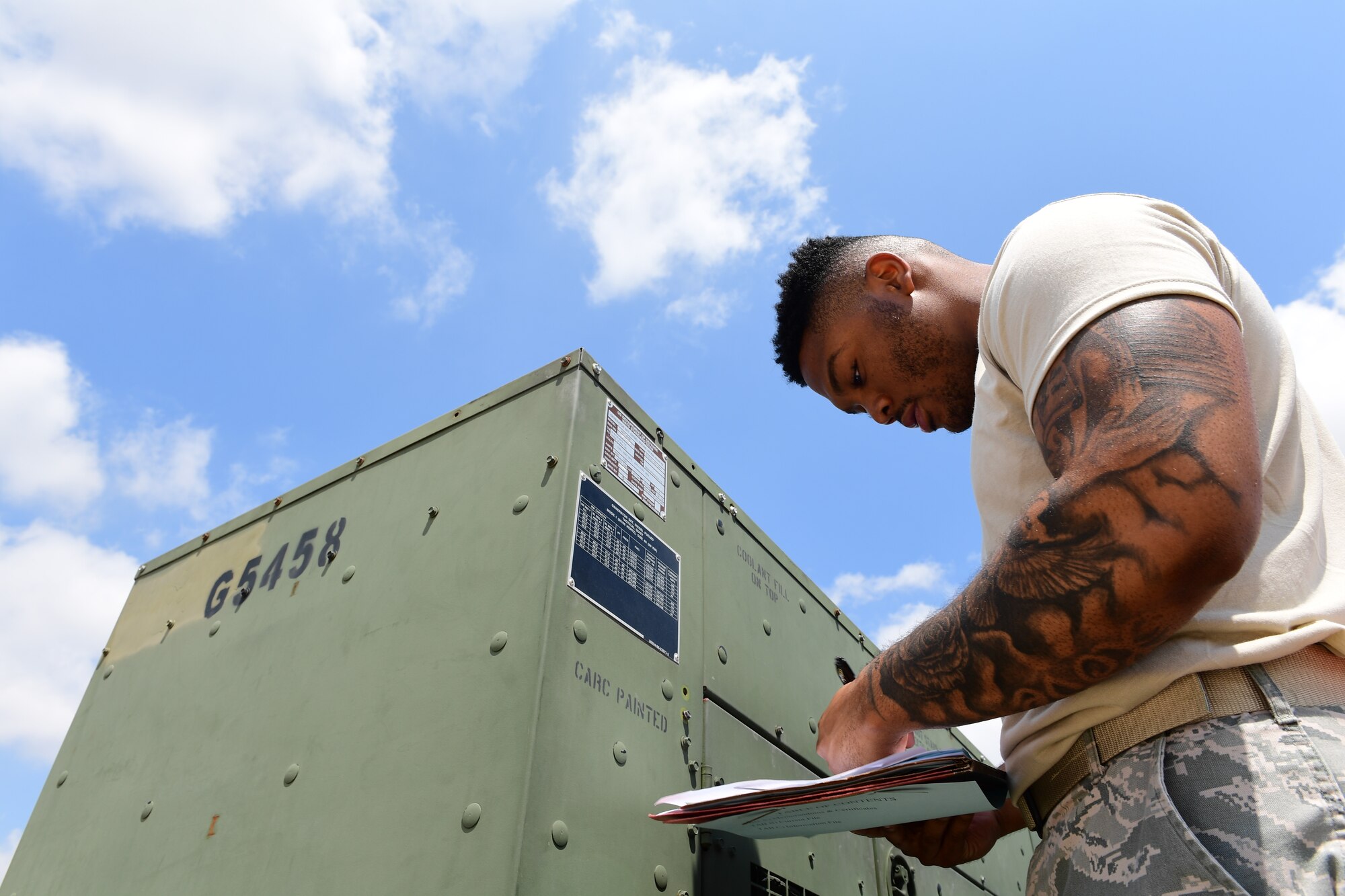 A logistics Airman inspects a piece of equipment against a reference sheet at Incirlik Air Base, Turkey