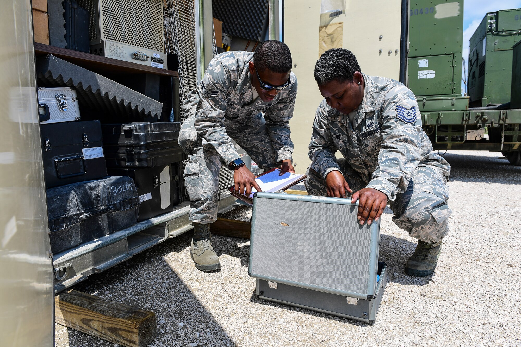 Two logistics Airmen inspect a piece of equipment from a storage area at Incirlik Air Base, Turkey