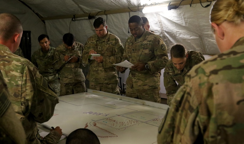 First Lt. Elijah Lake, platoon leader for Bravo Battery, 1st Battalion, 14th Field Artillery Regiment, 65th Field Artillery Brigade, Task Force Spartan, briefs the operation order for exercise Golden Sparrow to his Soldiers on June 27, 2018. The gathered Soldiers are High Mobility Artillery Rocket System gunners, drivers, crew chiefs and fire control specialists.