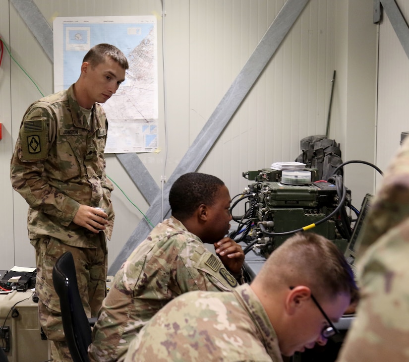 Spc. Thomas Johnston (left), Pfc. Raymond Jeter, and Spc. Dakota Whiteman, all fire control specialists for Bravo Battery, 1st Battalion, 14th Field Artillery Regiment, 65th Field Artillery Brigade, Task Force Spartan, coordinate fire missions to the High Mobility Artillery Rocket System crews from the fire direction center during the Golden Sparrow exercise on June 29, 2018.