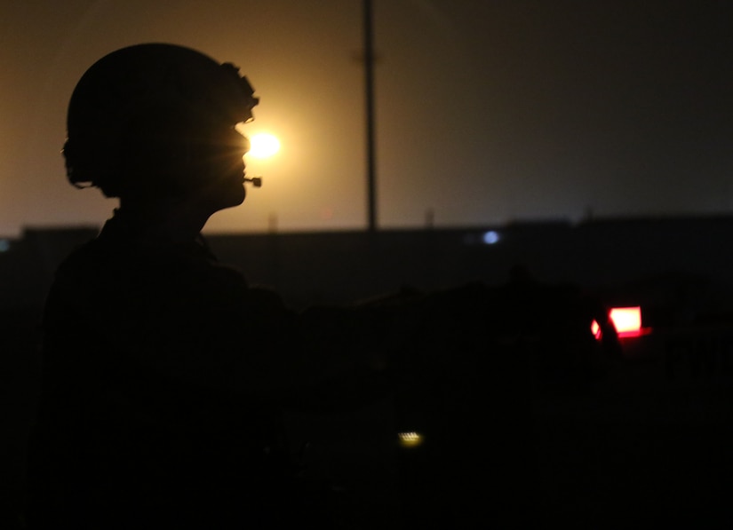 Cpl. Nicholas Read, a High Mobility Artillery Rocket System crewmember from Bravo Battery, 1st Battalion, 14th Field Artillery Regiment, 65th Field Artillery Brigade, Task Force Spartan, signals to the other Soldiers in his crew with a red chem light as they reload their HIMARS during the Golden Sparrow exercise on June 29, 2018.