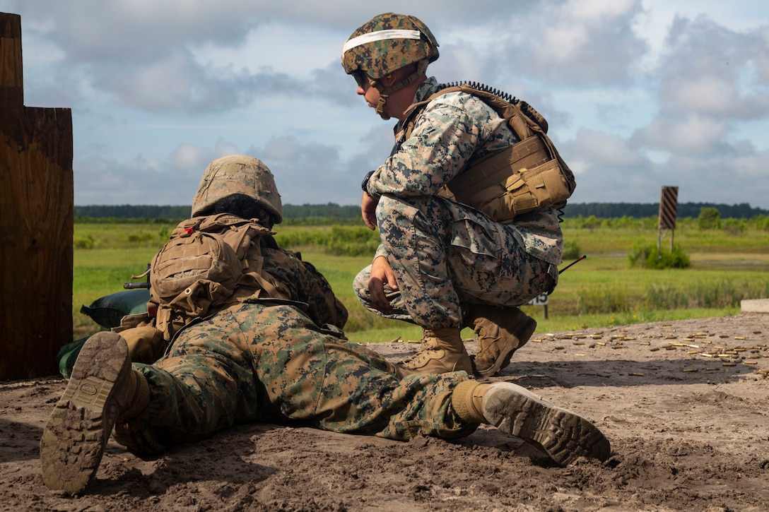 U.S. Marine Corps Staff Sgt. Henry Jones, combat instructor, Fox Company, Marine Combat Training Battalion (MCT), School of Infantry-East, monitors a Marine firing a M16A4 Service Rifle during Table 3 and 4 marksmanship training, Camp Lejeune, N.C., June 27, 2018. MCT conducts standards-based common combat skills training of entry-level Marines in order to create riflemen for service throughout the Marine Corps. (U.S. Marine Corps photo by Lance Cpl. Ashley Gomez)