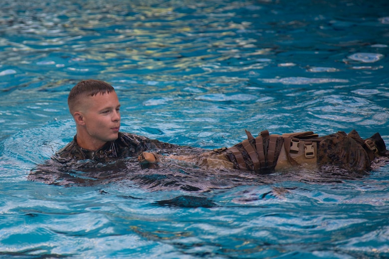A Marine with Headquarters and Support Battalion, Marine Corps Installations East, Marine Corps Base Camp Lejeune, participates in the basic swim qualification course at the Area 5 Training Tank on MCB Camp Lejeune, N.C., July 2, 2018. The Marine Corps Water Survival Training Program employs water survival skills of increasing levels of ability designed to help Marines survive in the water. (U.S. Marine Corps photo by Lance Cpl. Ashley D. Gomez)