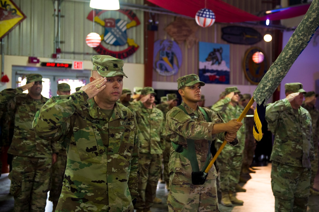 Soldiers in formation salute.