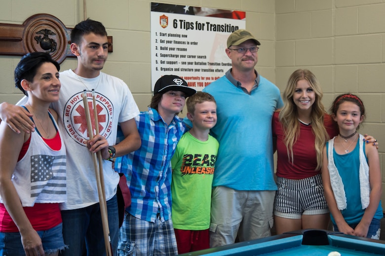 Country music singer Lindsay Ell, wearing a red shirt, was welcomed to Wounded Warrior Battalion-East, Marine Corps Base Camp Lejeune by friends and family of recovering service members at WWBN-E, MCB Camp Lejeune, July 4. Ell received a tour of WWBn-E and saw the different types of therapy available to recovering service members, hours before her performance at Camp Lejeune’s BaseFEST – an annual public Independence Day celebration hosted by the base. (U.S. Marine Corps photo by Cpl. Nikki L. Morales)