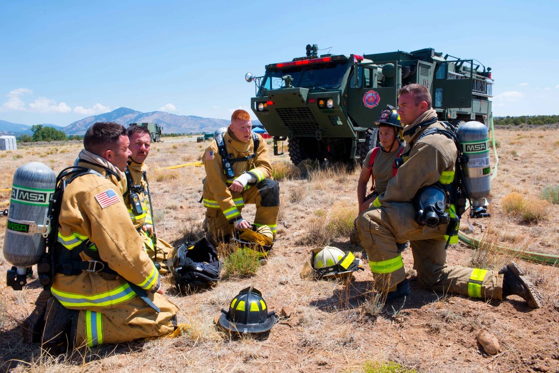 Soldiers discuss firefighting techniques while taking a break from training.
