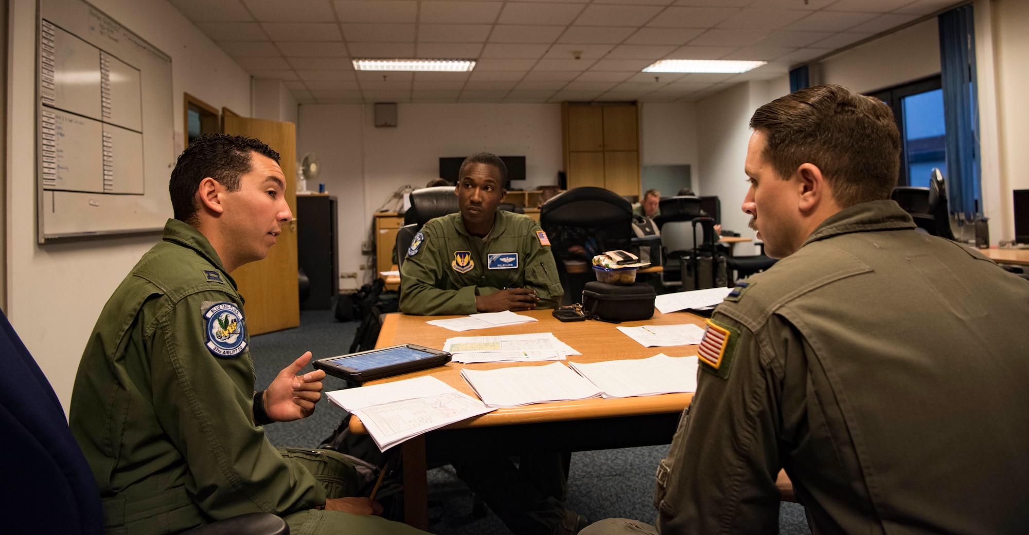 U.S. Air Force Capt. Joshua Rodriguez, 86th Operational Support Squadron Current Operations officer, discusses with Maj. Willie Lloyd, 37th Airlift Squadron director of staff, and Capt. James Denoyer, 37th Airlift Squadron resource advisor, about the logistics of carrying out an exercise where five C-130J Super Hercules aircraft flew together in formation over Germany, on July 2, 2018. In total, 21,800 pounds of training cargo were airdropped on Bunker DZ in eastern Germany near United States Army Garrison Grafenwoehr.