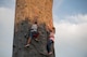 Two children climb up a rock wall prior to an Intel drone light show at Travis Air Force Base, Calif., July 5, 2018. The event featured numerous activities including music, bounce houses and an eight minute light show with 500 drones. (U.S. Air Force photo by Tech. Sgt. James Hodgman)