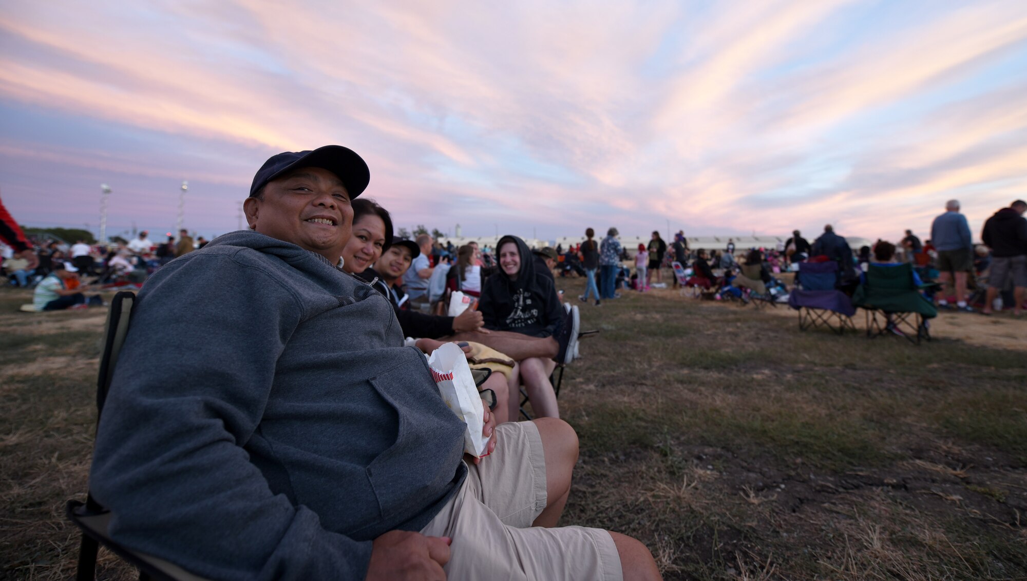 A family sits in anticipation of Travis Air Force Base Calif.'s drone light show July 5, 2018. In addition to the light show, the celebration included a rock wall, bounce houses and food trucks for Travis families. (U.S. Air Force photo by Airman 1st Class Christian Conrad)