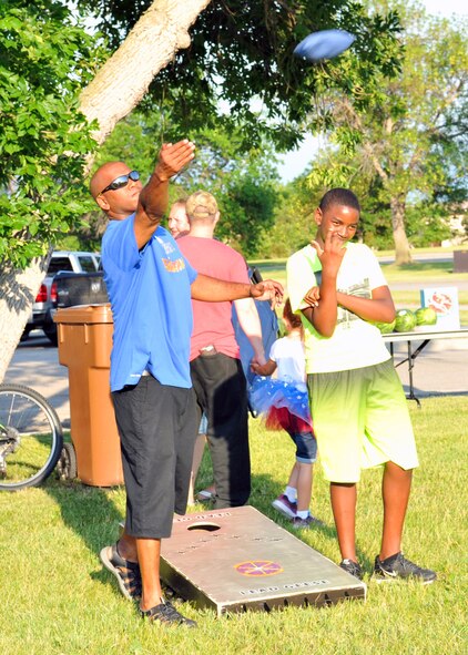Tech Sgt. Anthony Hallock, 319th Operations Support Squadron air fuel systems NCO-in-charge, tosses a bean bag during a game of corn hole at Freedom Fest July 3, 2018, at Grand Forks Air Force Base, North Dakota. A corn hole tournament was one of many activities held during Freedom Fest for families to enjoy. (U.S. Air Force photo by Staff Sgt. Marcy Copeland)