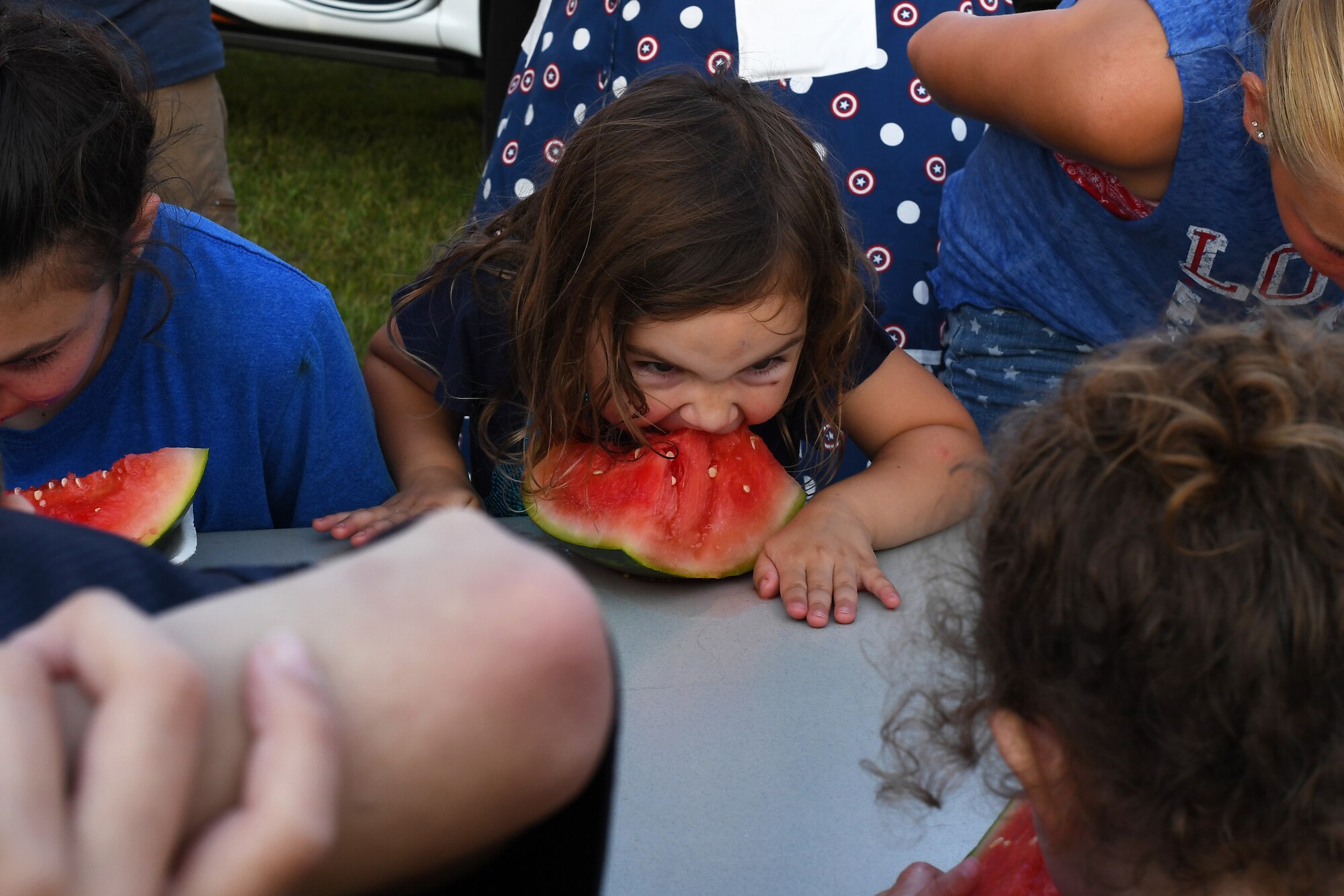 Children participate in a timed watermelon-eating competition during the Freedom Fest hosted on July 3, 2018, on Grand Forks AFB, North Dakota. More than 300 military members, families and friends gathered for the first annual which featured live music, games, bouncy houses, fireworks and more. (U.S. Air Force photo by Airman 1st Class Elora J. Martinez)