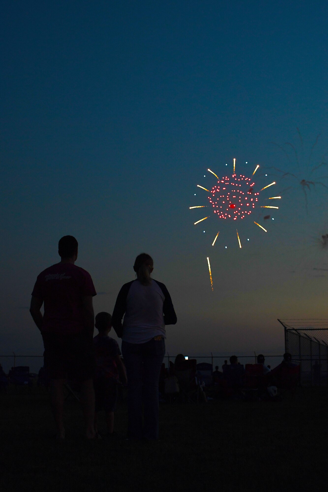 A Grand Forks Air Force Base family admires a firework show over the flight line, which marked the end of the first annual Freedom Fest hosted on July 3, 2018, at Grand Forks AFB, North Dakota. Several hundred military members, friends and families attended the event, which celebrated Independence Day. (U.S. Air Force photo by Airman 1st Class Elora J. Martinez)