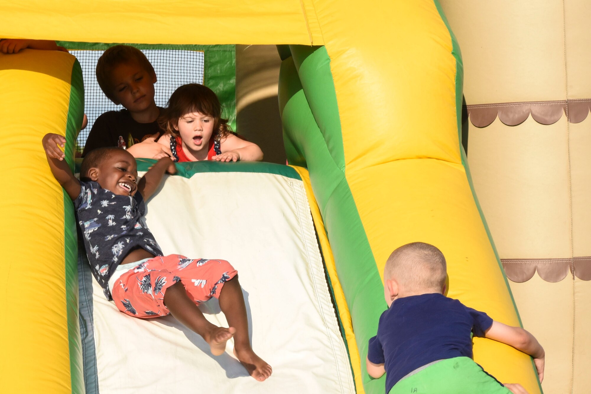 Children enjoy the inflatable slide at Freedom Fest July 3, 2018, on Grand Forks Air Force Base, North Dakota. The slide, along with the rest of the inflatable playground, was open to children of all ages, and gave parents a chance to enjoy the event with while occupying their little ones. (U.S. Air Force photo by Airman 1st Class Melody Wolff)