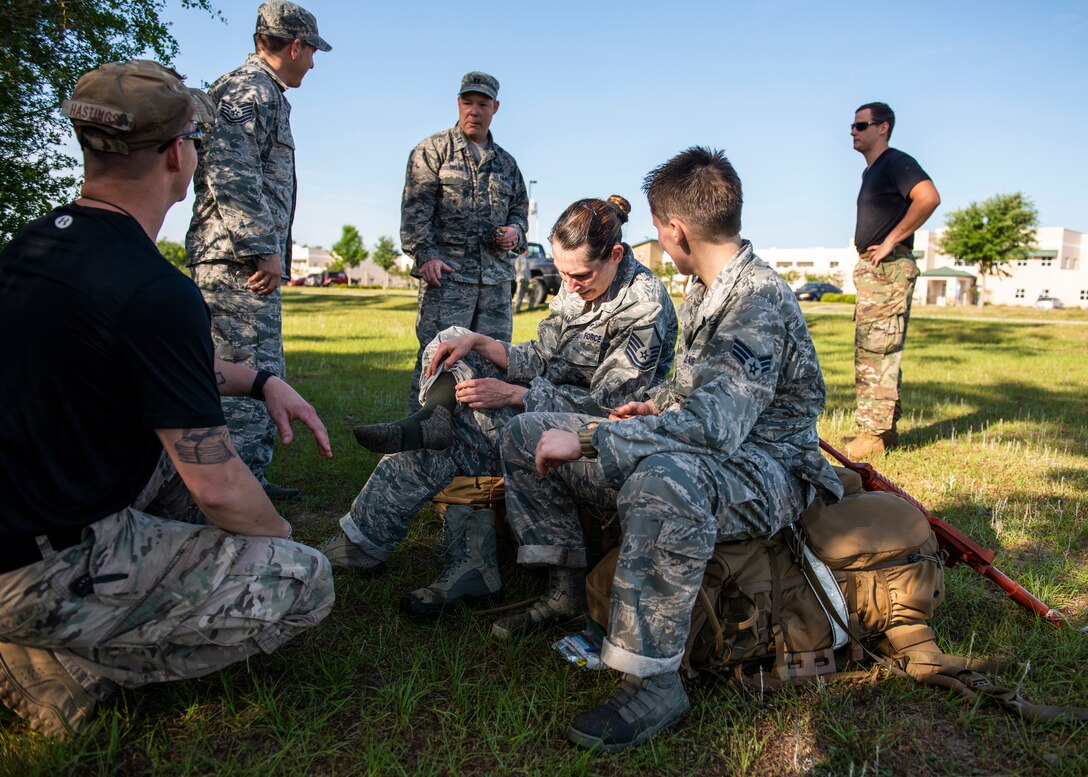 Master Sgt. Kay Williams, 919th Special Operations Security Forces Squadron, treats blisters on her feet moments after she and fellow team members completed a seven-mile ruck march May 5, 2018 near Duke Field, Fla.