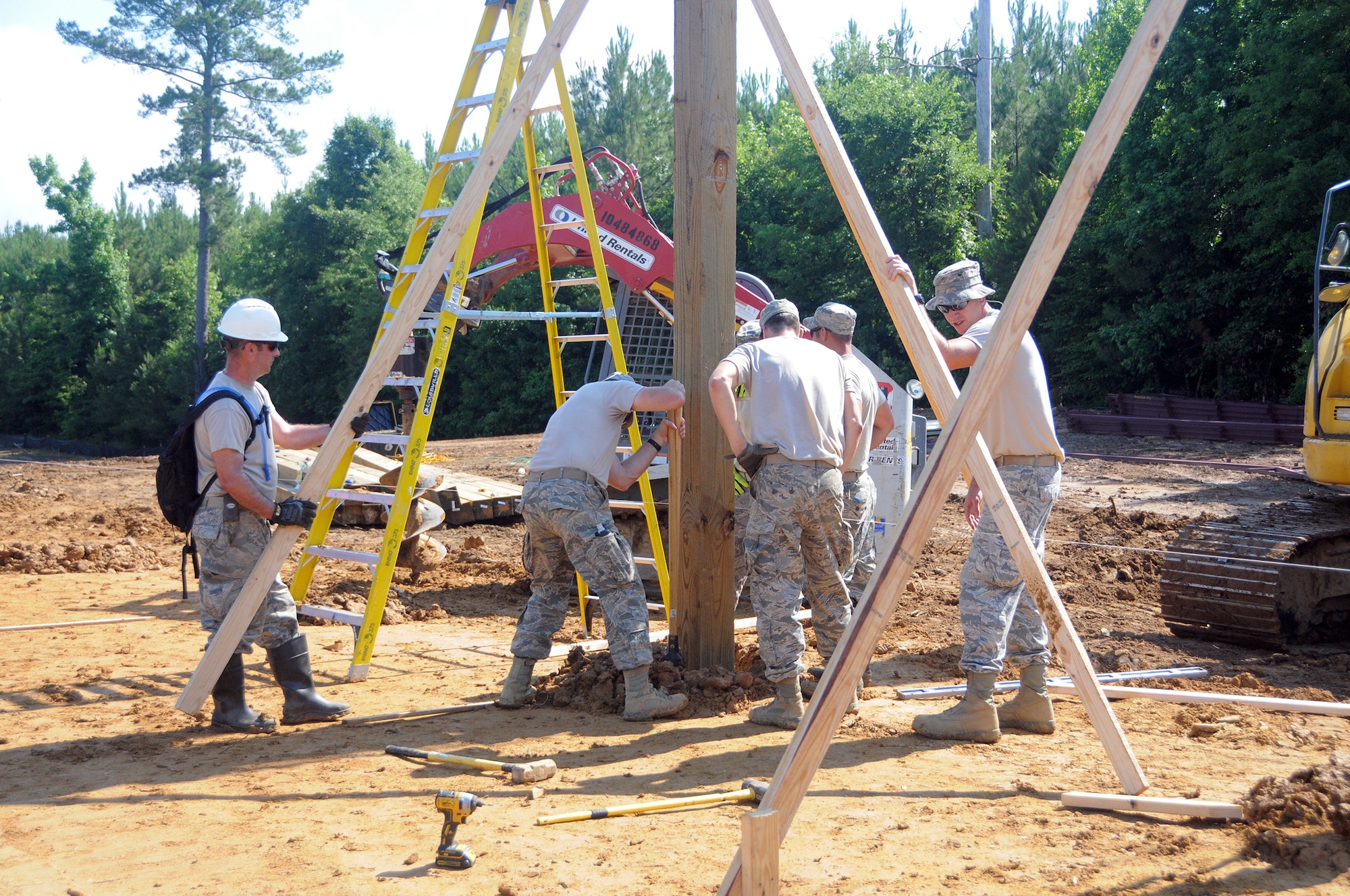 Staff Sgt. Brian Wood, 445th Civil Engineer Squadron structural journeyman (far left) and members of the Air National Guard’s 189th CES from Little Rock Air Force Base, Arkansas, place a beam for a pole barn at Camp Kamasa, Crystal Springs, Mississippi, June 6, 2018.