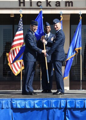 Lt. Gen. Kenneth Wilsbach, 11th Air Force commander, passes the Wing guidon to incoming 15th Wing commander, Colonel W. Halsey Burks on June 20, 2018 at the 15th Wing Change of Command ceremony on Hickam Field, Joint Base Pearl Harbor-Hickam, Hawaii.