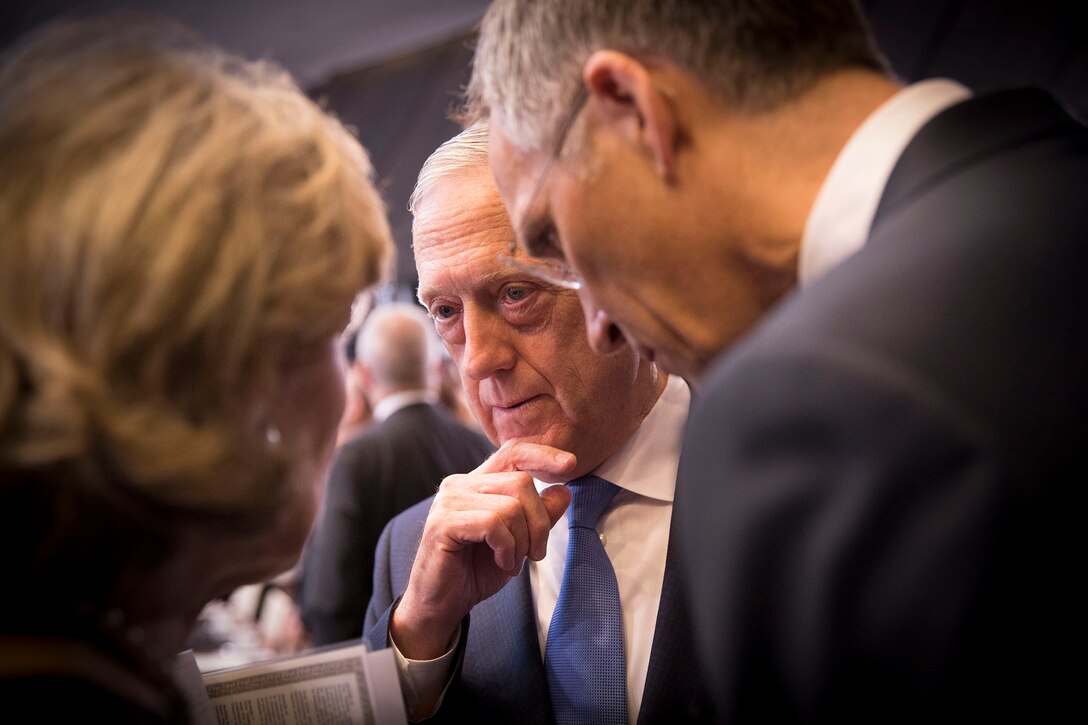 Defense Secretary James N. Mattis has a discussion with two people.