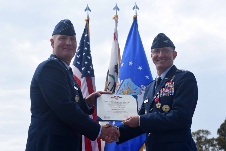 Col. Michael Hough, 30th Space Wing commander, presents the legion of merit to Col. Paul Nosek, 30th Mission Support Group outgoing commander, during the 30th MSG change of command ceremony on July 12, 2018, at Vandenberg Air Force Base, Calif. The 30th MSG provides security, law enforcement, disaster response, civil engineer, base services, mission support, morale services, contracting, and logistical support. (U.S. Air Force photo by Tech. Sgt. Jim Araos/Released)