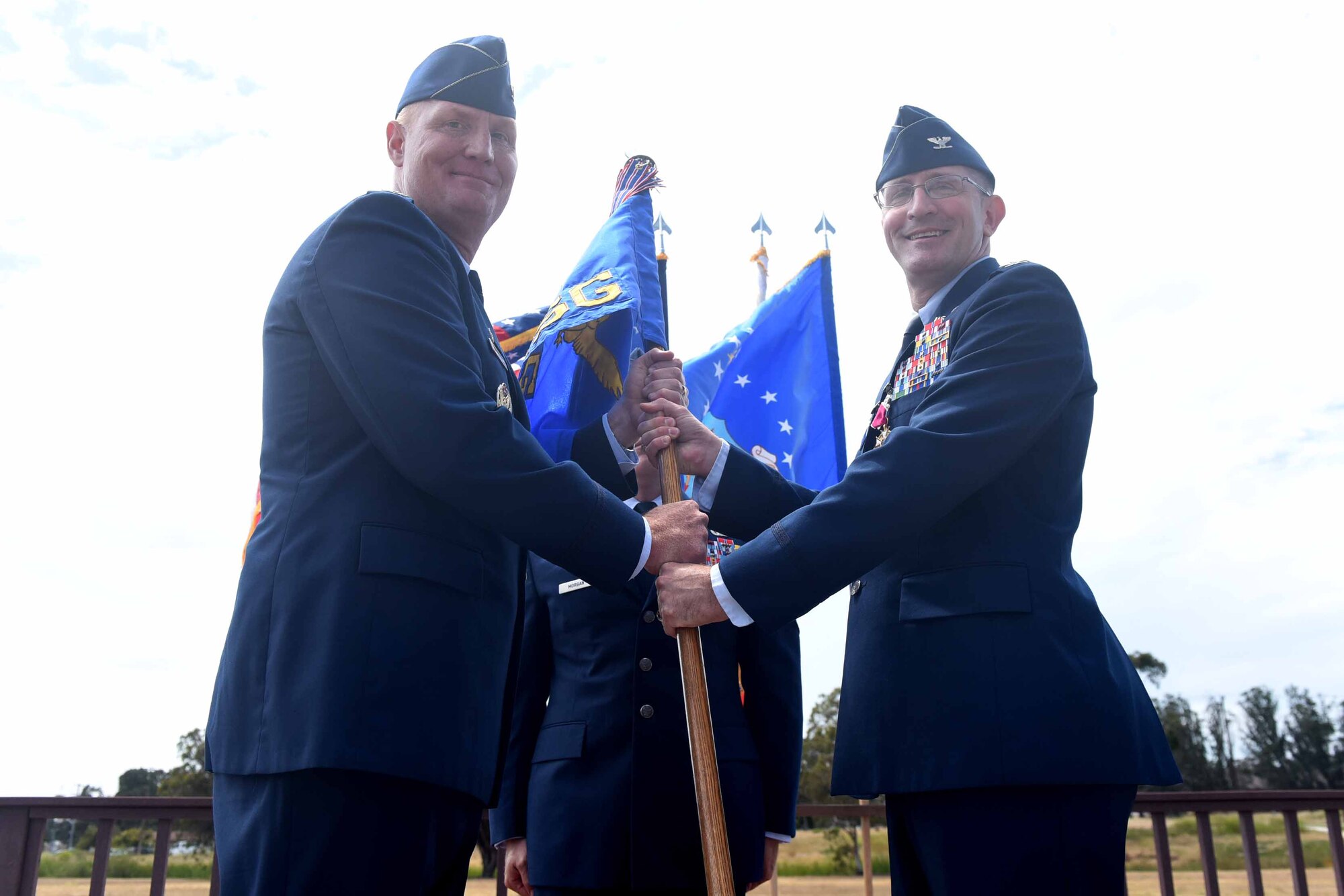 Col. Paul Nosek, 30th Mission Support Group outgoing commander, relinquishes command on the 30th MSG and passes the guide on to Col. Michael Hough, 30th Space Wing commander, during the 30th MSG change of command ceremony on July 12, 2018, at Vandenberg Air Force Base, Calif. The 30th MSG provides security, law enforcement, disaster response, civil engineer, base services, mission support, morale services, contracting, and logistical support. (U.S. Air Force photo by Tech. Sgt. Jim Araos/Released)