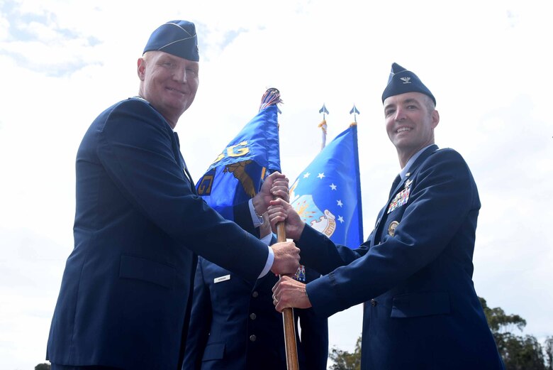 Col. Michael Hough, 30th Space Wing commander, passes the guide on to Col. Michael Hunsberger, 30th Mission Support Group inbound commander, during the 30th MSG change of command ceremony on July 12, 2018, at Vandenberg Air Force Base, Calif. The 30th MSG provides security, law enforcement, disaster response, civil engineer, base services, mission support, morale services, contracting, and logistical support. (U.S. Air Force photo by Tech. Sgt. Jim Araos/Released)