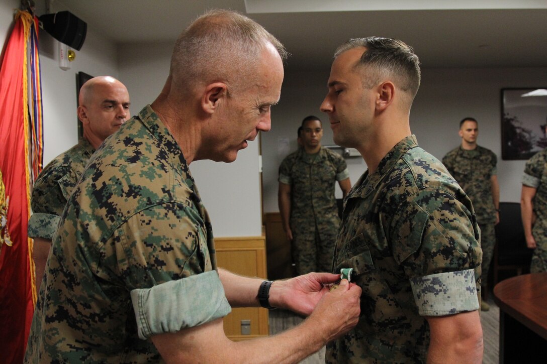 USAG CAMP HUMPHREYS – Maj. Gen. Patrick J. Hermesmann (left), U.S. Marine Corps Forces Korea commander, awards Staff Sgt. Christopher A. Keller, protocol protective services driver staff non-commissioned officer in charge, a Navy and Marine Corps Commendation Medal for his outstanding performance at Marine Corps Air Station Miramar California, here, July 10. Keller was awarded for his contributions as a criminal investigator with Criminal Investigation Division. (U.S. Marine Corps photo by Sgt. Nathaniel Hanscom/Released)
